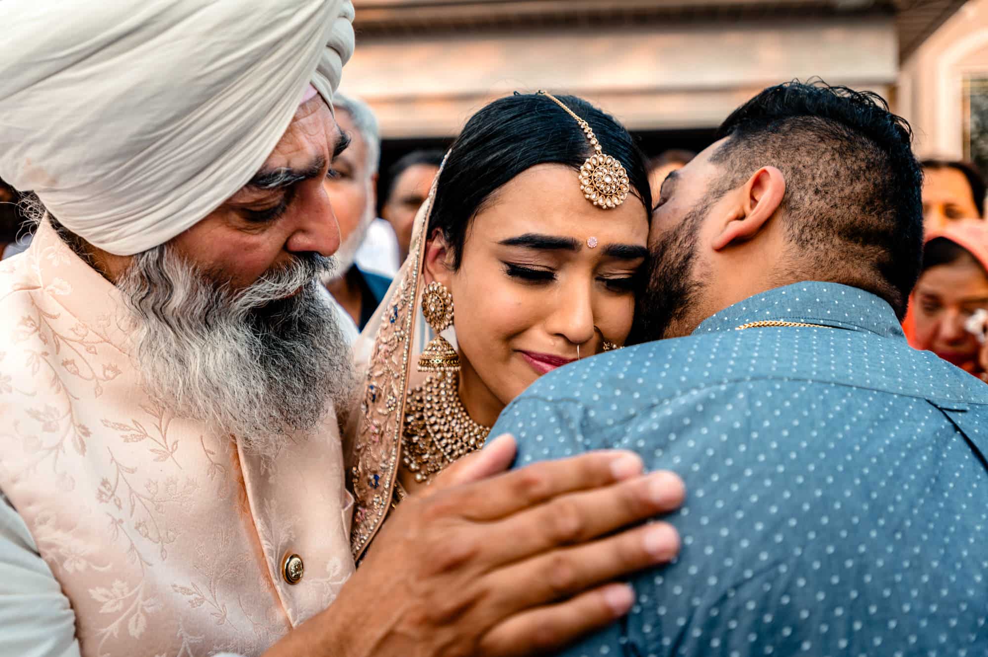 An emotional goodbye during the Doli ceremony with bride and her father in an emotional hug with tears.