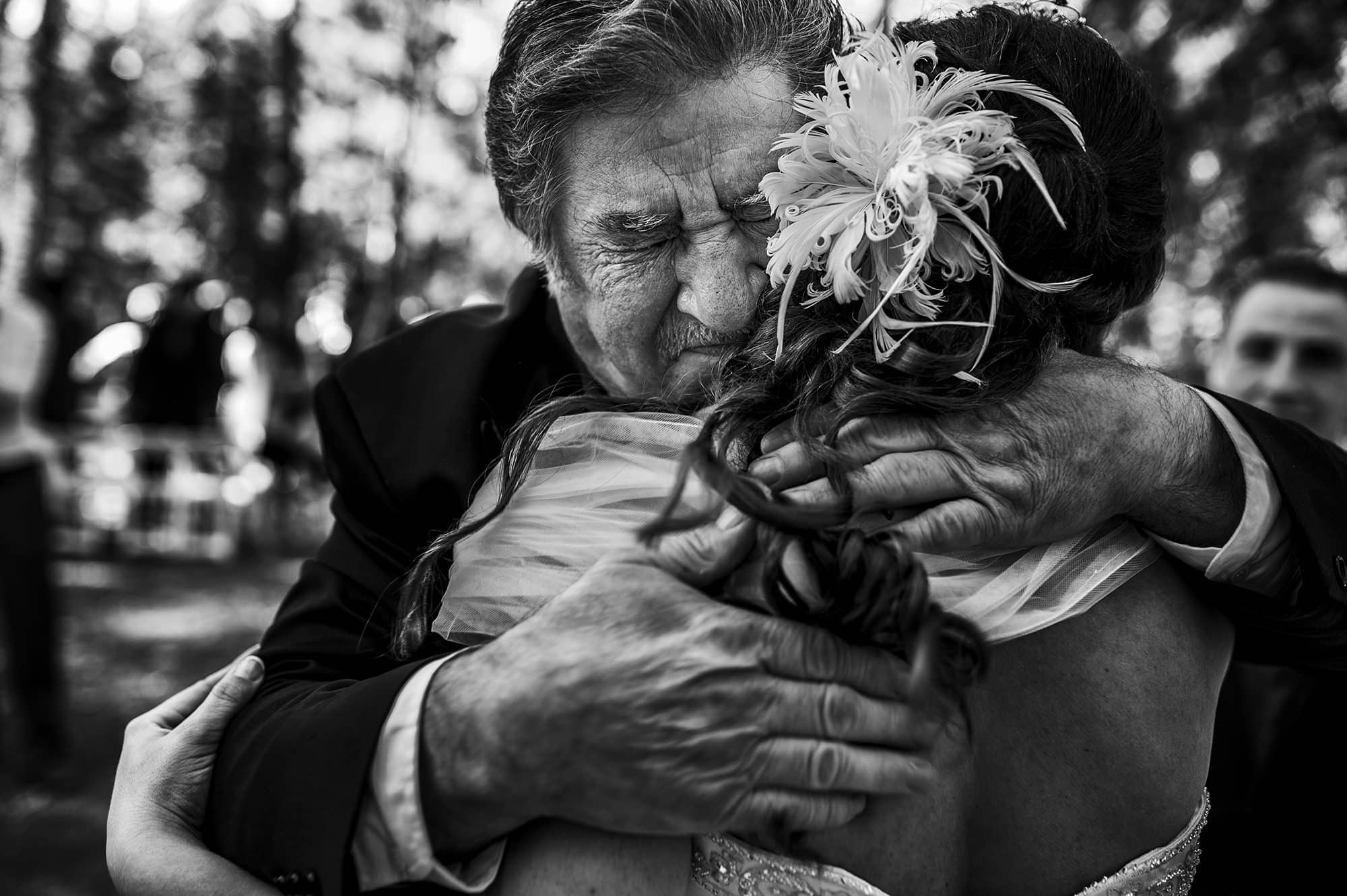 Winnipeg Wedding Photographer captured an emotional hug between father and bride after wedding ceremony.